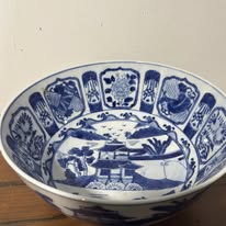 Blue and white porcelain bowl with oriental motifs.