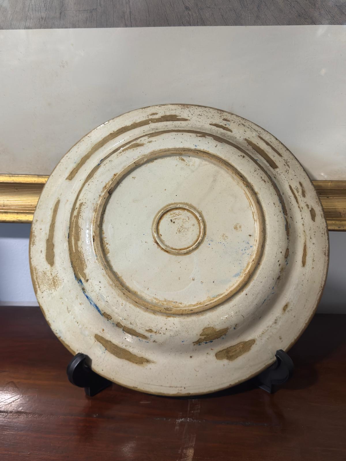 Blue and white porcelain plate with oriental landscape and gold details.